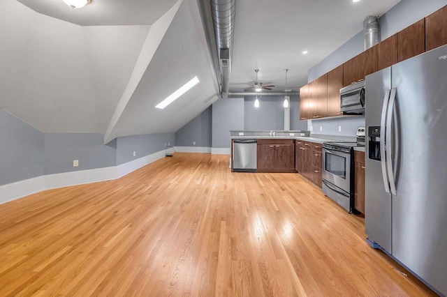 kitchen featuring pendant lighting, lofted ceiling, ceiling fan, light wood-type flooring, and appliances with stainless steel finishes