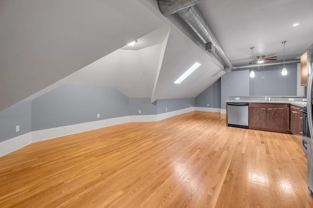 additional living space with ceiling fan, light wood-type flooring, sink, and vaulted ceiling