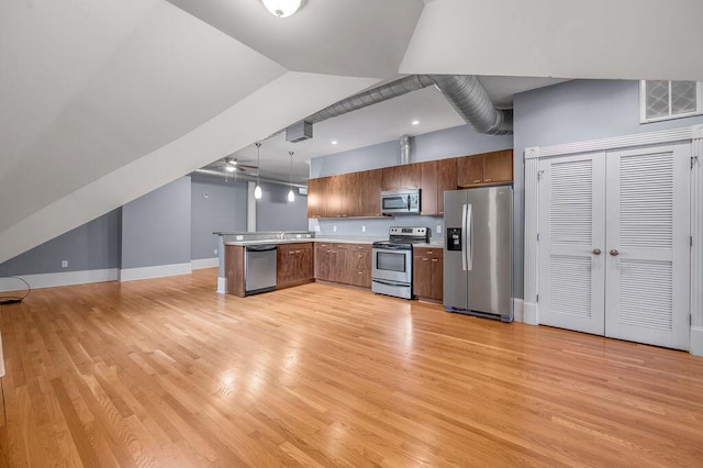 kitchen with light hardwood / wood-style floors, kitchen peninsula, stainless steel appliances, and hanging light fixtures