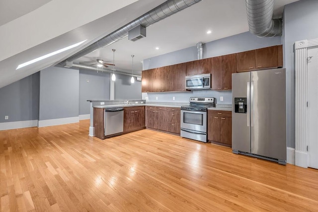 kitchen featuring hanging light fixtures, light hardwood / wood-style flooring, ceiling fan, appliances with stainless steel finishes, and kitchen peninsula