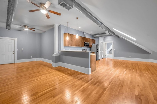 kitchen with kitchen peninsula, a kitchen breakfast bar, stainless steel appliances, light hardwood / wood-style floors, and hanging light fixtures