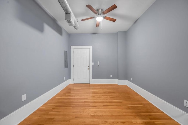 empty room with light wood-type flooring, electric panel, and ceiling fan