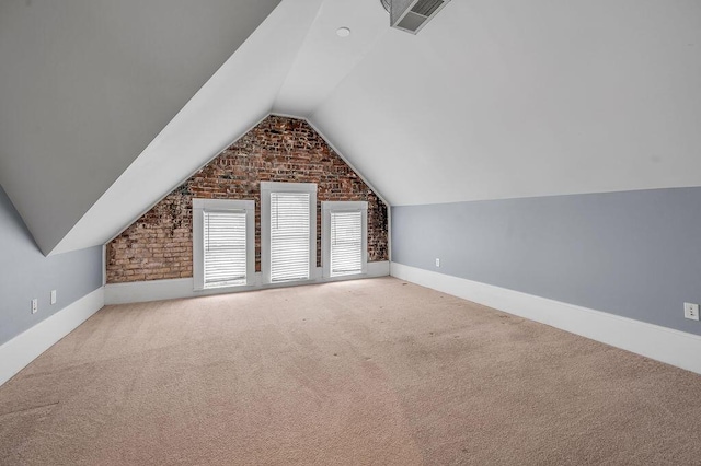 bonus room featuring carpet floors, lofted ceiling, and brick wall