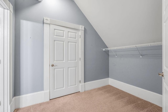 spacious closet featuring carpet flooring and vaulted ceiling