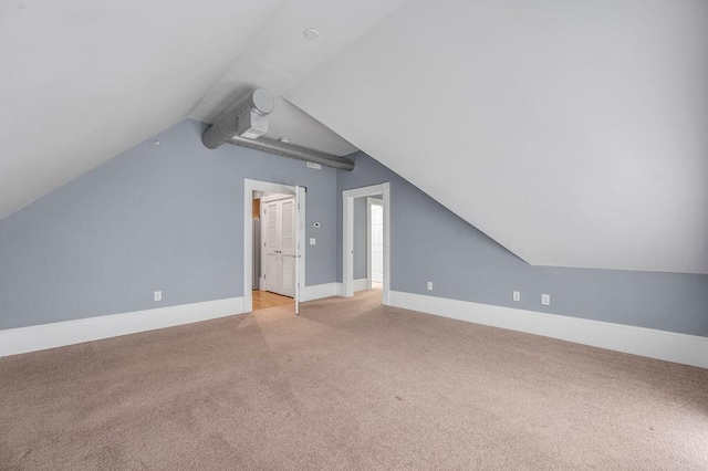 additional living space with light carpet and lofted ceiling