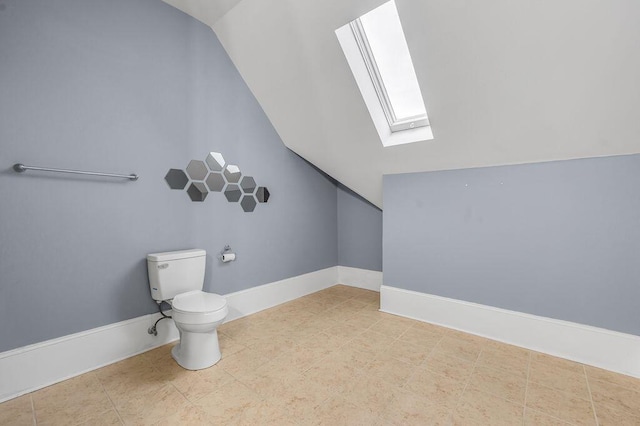 bathroom featuring toilet and vaulted ceiling with skylight