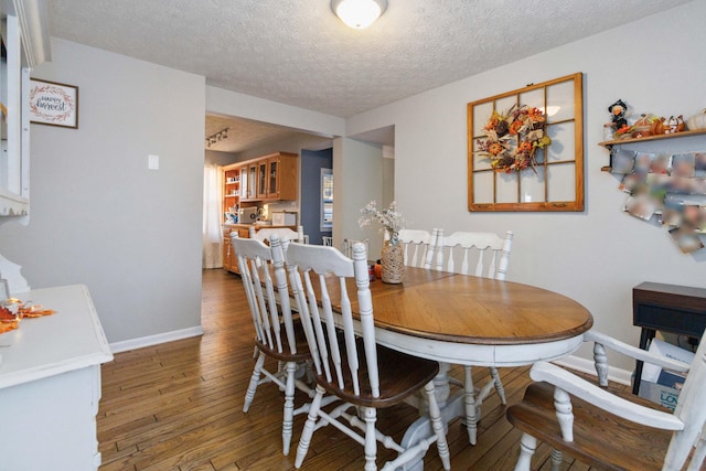 dining room featuring dark hardwood / wood-style floors and a textured ceiling