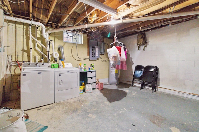 basement featuring electric panel, water heater, and washer and dryer