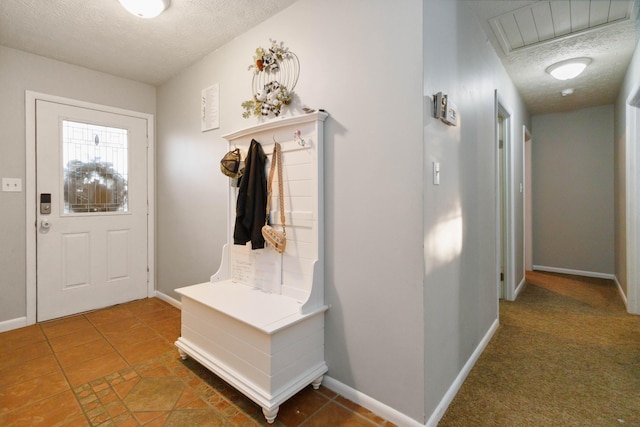 mudroom featuring dark colored carpet and a textured ceiling