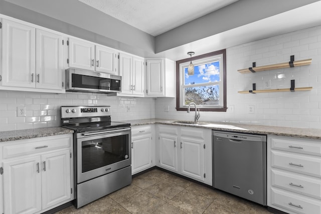 kitchen with sink, decorative backsplash, stainless steel appliances, and white cabinets