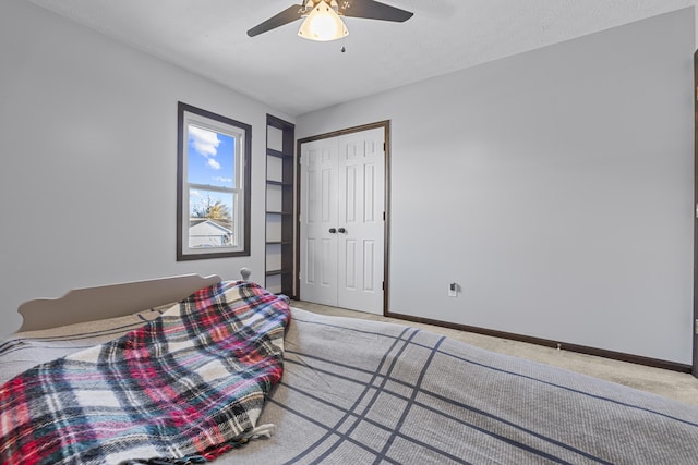 carpeted bedroom with ceiling fan, a closet, and a textured ceiling