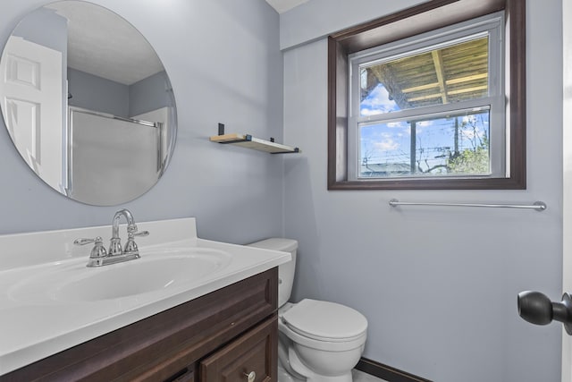 bathroom with vanity, toilet, and a shower with door