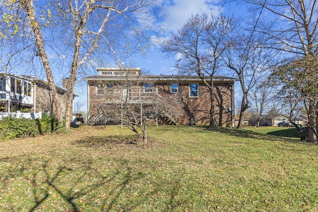 back of property with a wooden deck and a yard