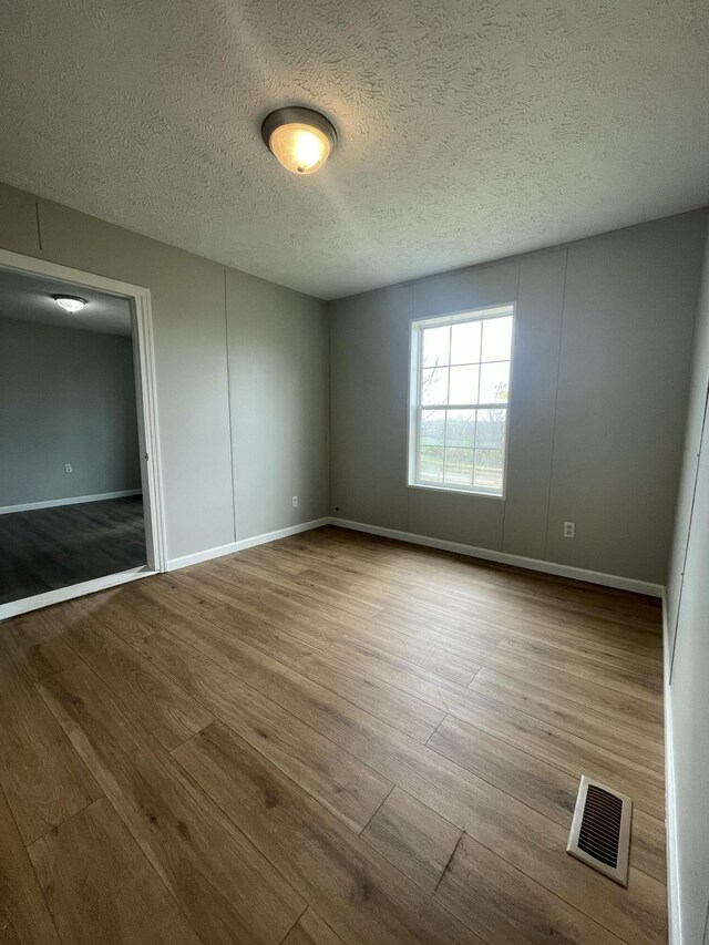 1455 Nepton Rd, Ewing, KY 41039 - unfurnished bedroom featuring wood finished floors, baseboards, and a textured ceiling
