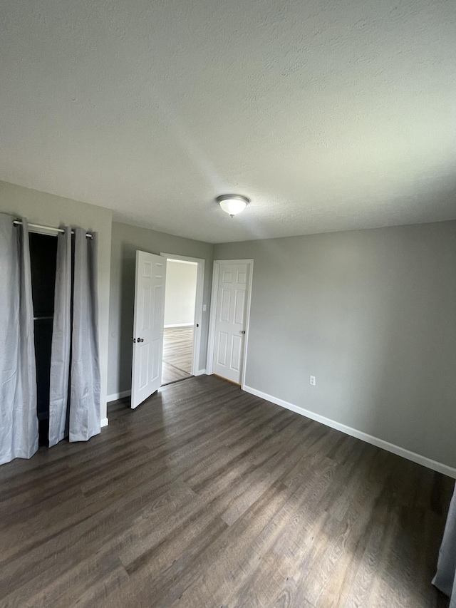 1455 Nepton Rd, Ewing, KY 41039 - unfurnished bedroom with dark wood-type flooring, baseboards, and a textured ceiling