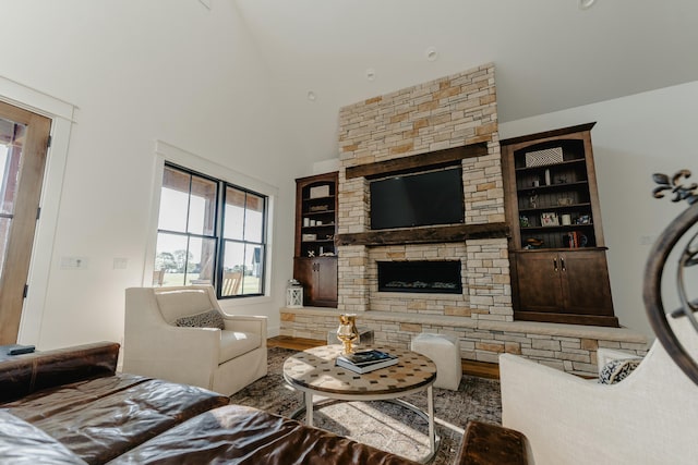 living room featuring built in shelves, hardwood / wood-style flooring, and vaulted ceiling