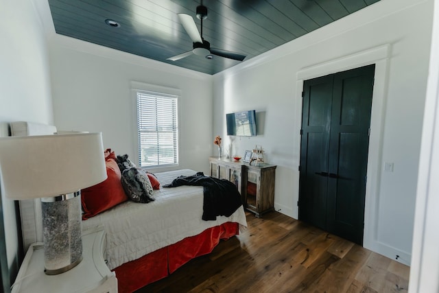 bedroom with ceiling fan, dark hardwood / wood-style flooring, wooden ceiling, and ornamental molding