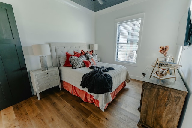 bedroom with hardwood / wood-style flooring and crown molding