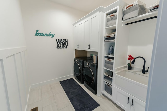 laundry room featuring cabinets, light tile patterned floors, sink, and washing machine and clothes dryer