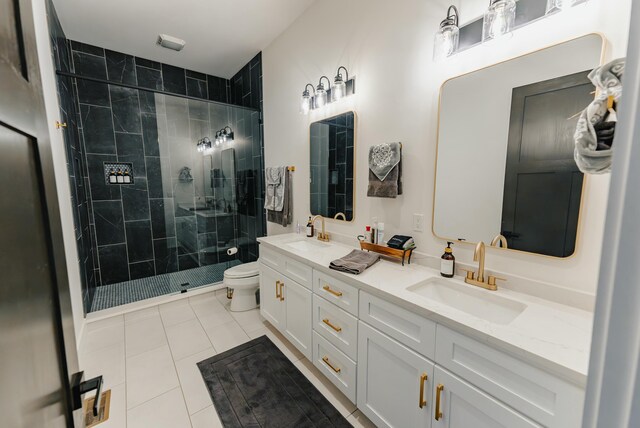 bathroom with tile patterned flooring, vanity, a shower with shower door, and toilet