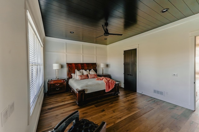 bedroom featuring ceiling fan, hardwood / wood-style floors, wooden ceiling, and ornamental molding