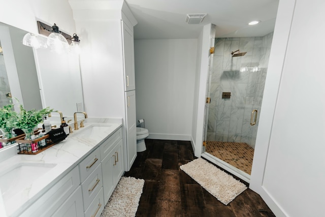 bathroom featuring wood-type flooring, vanity, toilet, and an enclosed shower