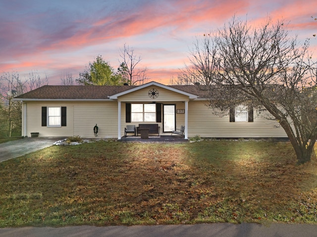 ranch-style home with a lawn and a patio