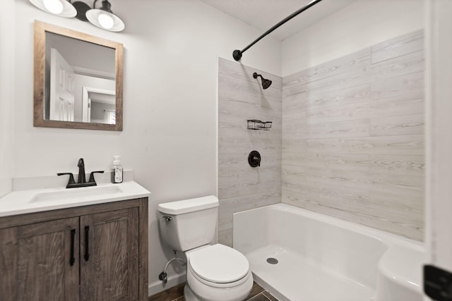 bathroom featuring a tile shower, vanity, and toilet