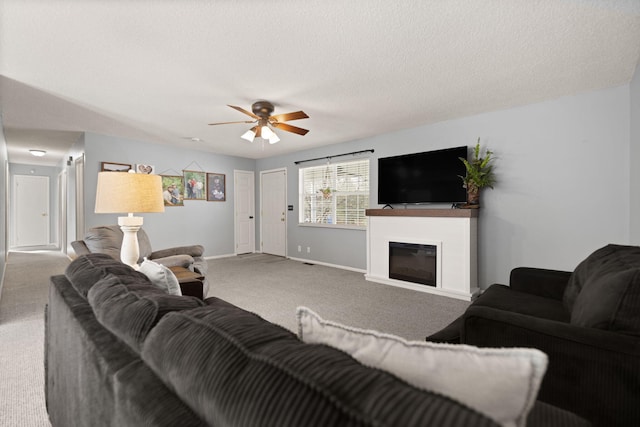 carpeted living room with a textured ceiling and ceiling fan