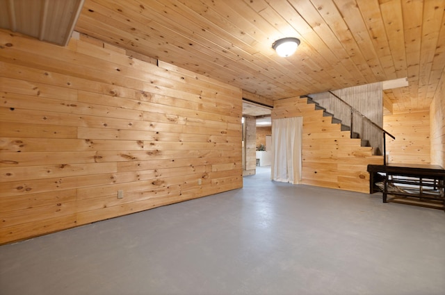 interior space with concrete flooring, wooden walls, and wood ceiling