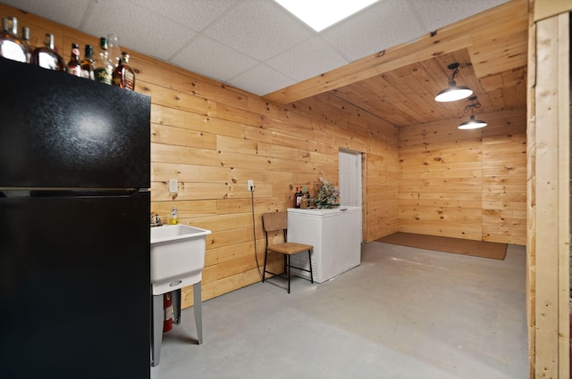 interior space featuring wood walls and concrete floors