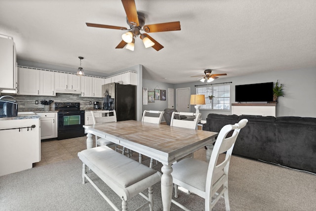 carpeted dining space featuring ceiling fan and a textured ceiling