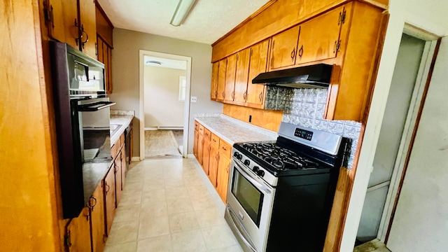 kitchen featuring stainless steel appliances, a baseboard radiator, and tasteful backsplash