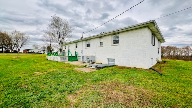 rear view of property with a wooden deck and a yard