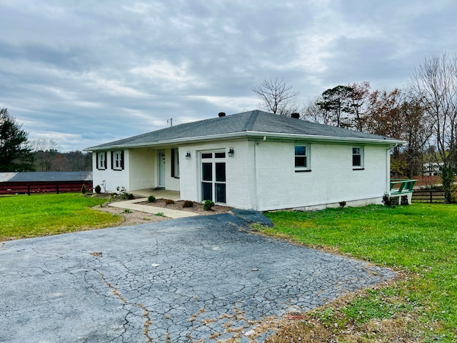 rear view of property featuring a lawn