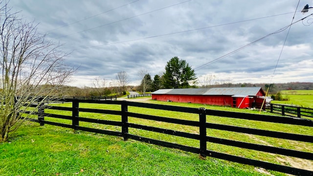 view of gate with a rural view and an outbuilding