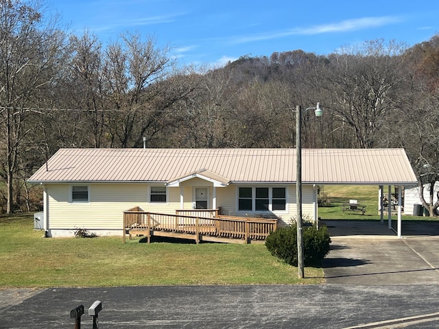 view of front facade with a deck and a front yard