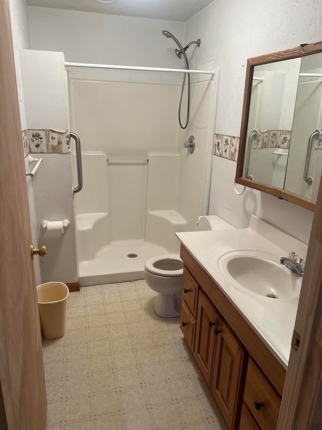 bathroom featuring walk in shower, vanity, and toilet