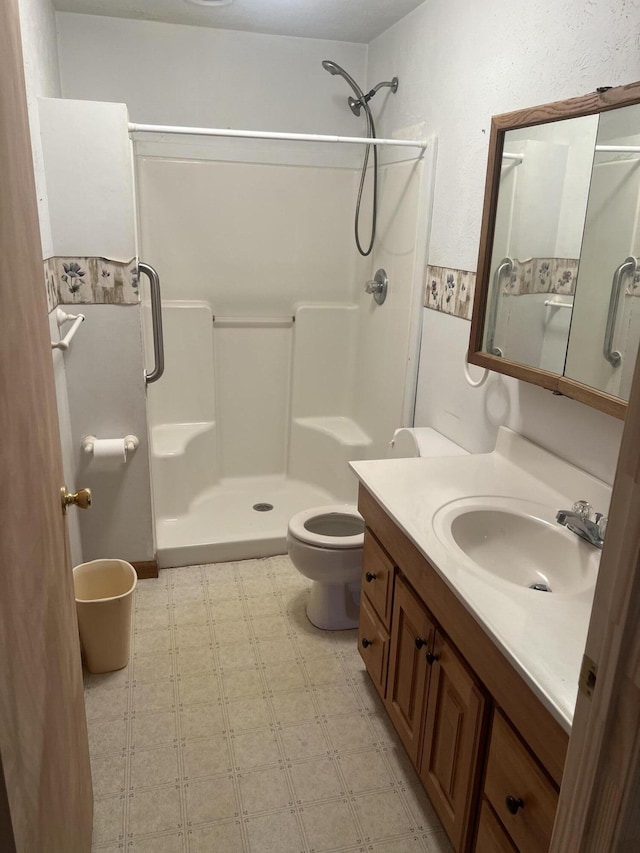full bathroom featuring tile patterned floors, a shower stall, vanity, and toilet