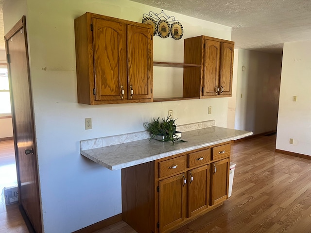 kitchen featuring hardwood / wood-style flooring, a textured ceiling, and an inviting chandelier