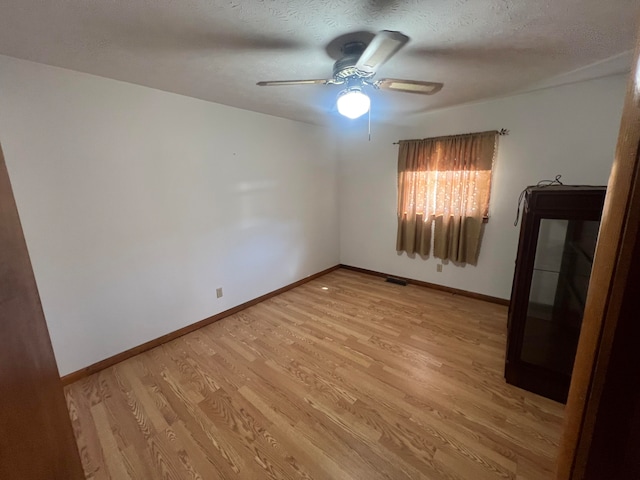 spare room featuring ceiling fan, a textured ceiling, and light wood-type flooring