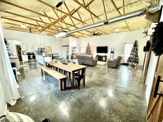 dining area with visible vents, a high ceiling, finished concrete floors, and a ceiling fan