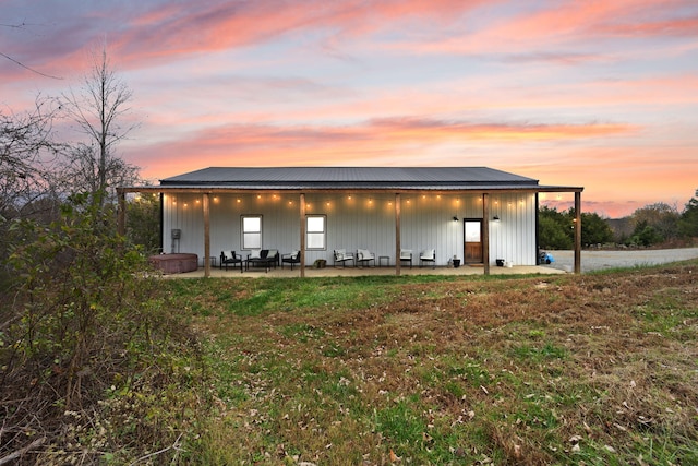 view of front facade featuring metal roof and a patio