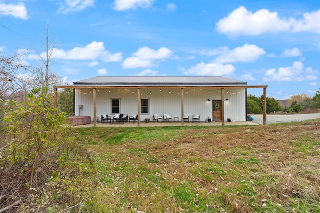 rear view of house with a patio area, metal roof, and a yard