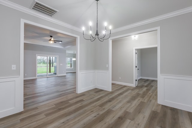 unfurnished dining area featuring ceiling fan with notable chandelier, wood-type flooring, and ornamental molding