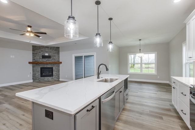 kitchen with white cabinets, sink, an island with sink, decorative light fixtures, and stainless steel appliances