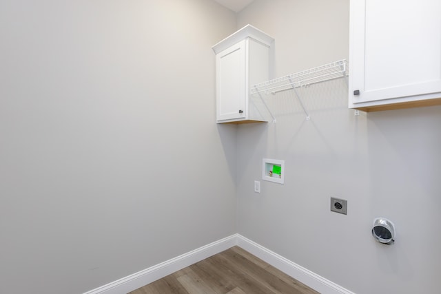 laundry room with electric dryer hookup, cabinets, hardwood / wood-style floors, and washer hookup