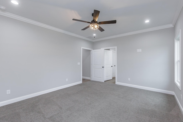 carpeted spare room with ceiling fan and crown molding