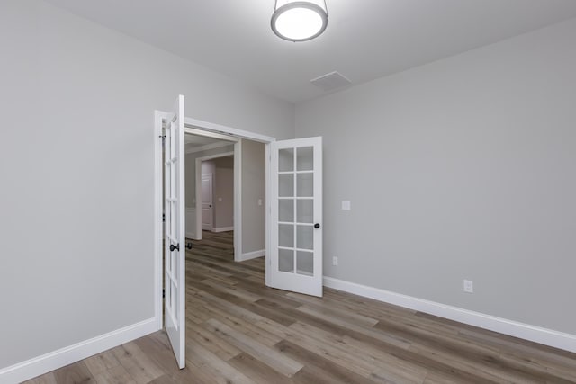 empty room with light hardwood / wood-style flooring and french doors