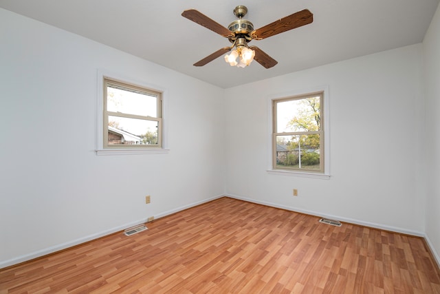 unfurnished room with light hardwood / wood-style floors, a healthy amount of sunlight, and ceiling fan